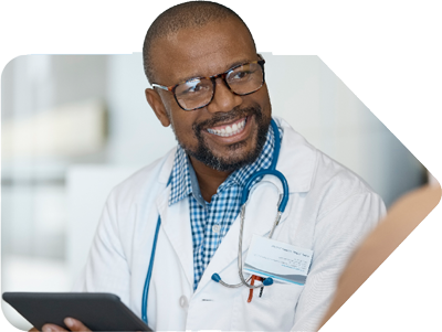 Male doctor smiling and holding a tablet.
