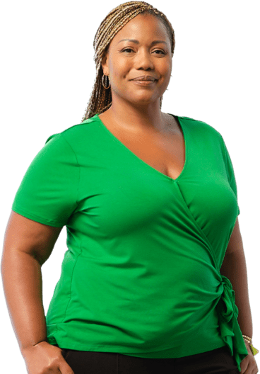 A woman wearing a green shirt standing confidently